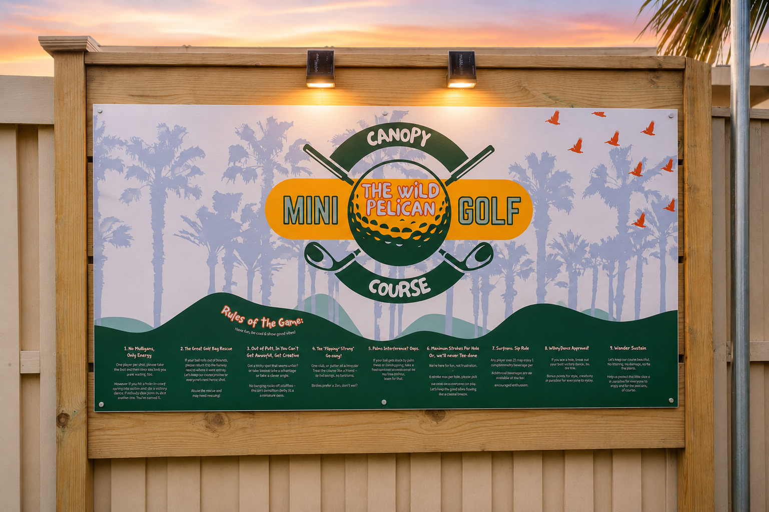 The Wild Pelican Canopy Mini Golf branded sign installed on a clean cedar fence at sunset, two warm solar wall lights glowing above the sign, palm tree silhouetted against a pink and orange dusk sky, Bradenton Florida family vacation rental amenity